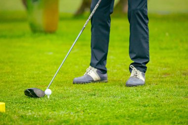 Golfçüye alçak açı vuruşu, güçlü golf topu vuruşu, golf vuruşuna başlamadan hemen önce. Golf sahasında golf sopası ile atış yaptı..