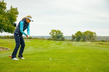 Zabalj, Voyvodina, Sırbistan - Ekim 04, 2025: Kadın golfçü, güçlü bir golfçü. Golf sahasında golf sopası ile atış yaptı..
