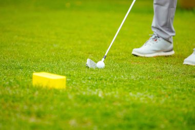 Golfçüye alçak açı vuruşu, güçlü golf topu vuruşu, golf vuruşuna başlamadan hemen önce. Golf sahasında golf sopası ile atış yaptı..