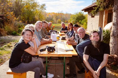 Tarash, Voyvodina, Sırbistan - 02 Kasım 2025: Toplanmış fotoğrafçılar, takılma, grup, fotoğraf kulübünün bir bölümü gibi şarapla konuşuyor ve eğleniyorlar.