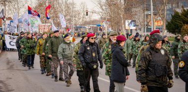 Zrenjanin, Sırbistan - 25 Ocak 2026: Öğrencilerin hükümet yolsuzluğu ve rejimine karşı düzenlediği protestoda bereli bir grup savaş gazisi, trajik bir kazada hayatını kaybeden 16 kişi için adalet talep ediyor
