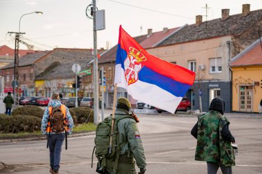 Zrenjanin, Sırbistan - 25 Ocak 2026: Öğrencilerin hükümet yolsuzluğu ve rejimine karşı düzenlediği protestoda bereli bir grup savaş gazisi, trajik bir kazada hayatını kaybeden 16 kişi için adalet talep ediyor