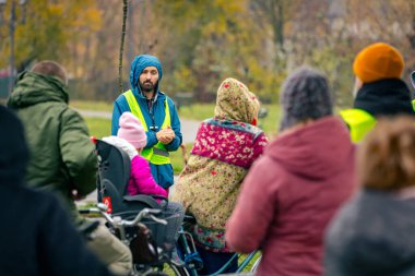 Zrenjanin, Voyvodina, Sırbistan - 29 Kasım 2025: Yağmurlu bir günde şehirde bisiklet sürmek için toplanan bir grup insan, şehir trafiğindeki bisikletçilerin tehlikesine dikkat çekmek için düdük kullanıyor.