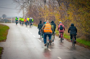 Yağmurlu bir günde bisiklete binen, şehirde bisiklete binen, kalabalık içinde araba kullanan bir grup genç, trafikteki ve kentsel çevredeki bisikletçiler için tehlikelere dikkat çekmeye çalışıyor..