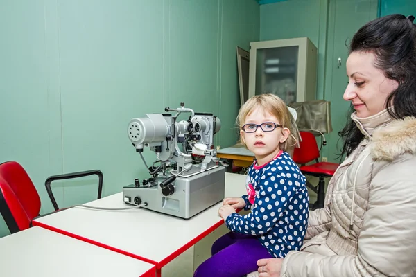 Eye exam, cute little girl is reviewing eyesight. — Stock Photo, Image