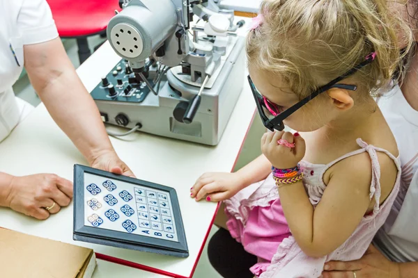 Child is at eye examination in clinic with special equipment. — Stock Photo, Image