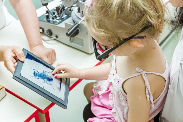 Child is at eye examination in clinic with special equipment.