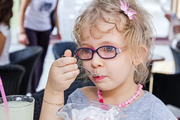 Meisje is het eten van ijs bij restaurant. — Stockfoto