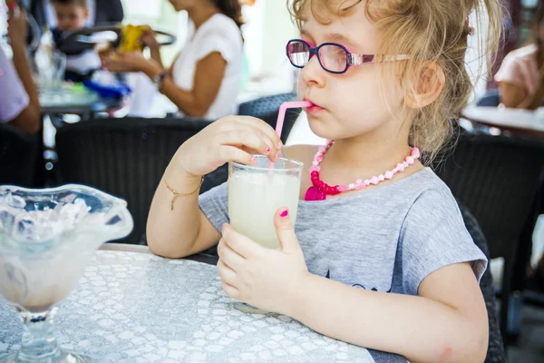 Küçük kız limonata restoranda içiyor. — Stok fotoğraf