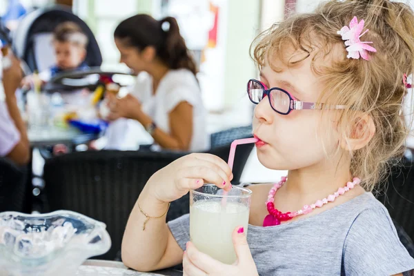 Meisje is limonade drinken bij restaurant. — Stockfoto