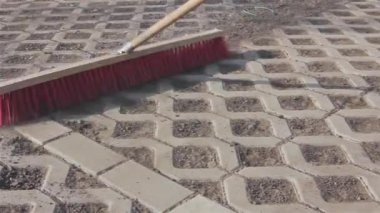 İşçi yeni park yeri kırmızı süpürge ile temizlik.