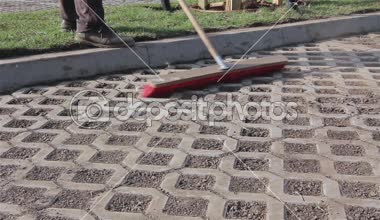 İşçi yeni park yeri kırmızı süpürge ile temizlik.