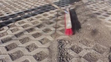 İşçi yeni park yeri kırmızı süpürge ile temizlik.