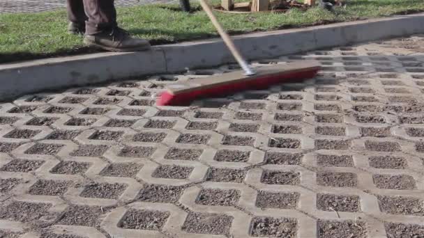 Trabalhador está limpando novo lugar de estacionamento com vassoura vermelha . — Vídeo de Stock