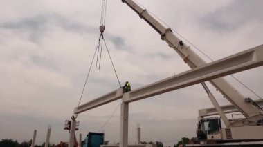 Yükseklik işçi iskelet bina truss çiziyor.