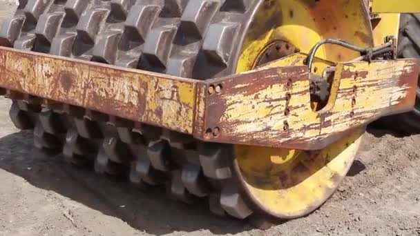 Riesige Straßenwalze mit Spikes verdichtet Boden an Baustelle. — Stockvideo