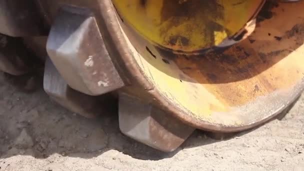 Enorme rodillo de carretera con espigas es compactar el suelo en el sitio de construcción . — Vídeo de stock