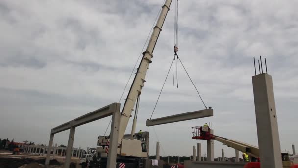 Mobile crane is operating, assembly concrete joist. — Stock Video