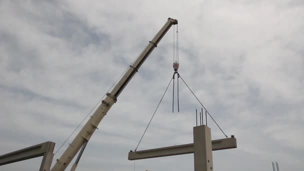 Mobile crane is operating and lifting concrete joist. — Stock Video