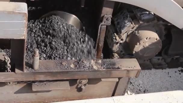 Metall skruv för leverans med varm asfalt i sprids maskin under vägbyggen. — Stockvideo