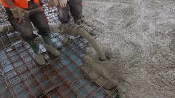Workers are spreading concrete over big reinforced floor on the construction site. — Stock Video