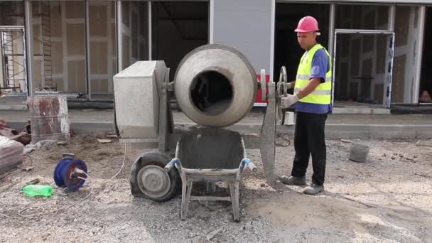 Trabalhador com um misturador de concreto — Vídeo de Stock