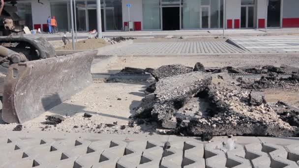 Bulldozer met emmer verwijdert gebroken asfalt, close-up. — Stockvideo