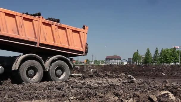 Muitos caminhões basculantes estão descarregando solo na mesma pilha . — Vídeo de Stock