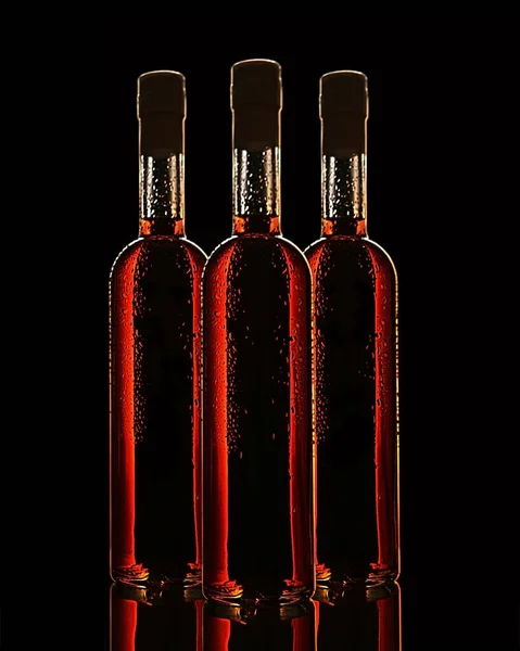 Három Üveg Sötétvörös Folyadék Marad Asztalon Tükröződve Fekete Háttér — Stock Fotó