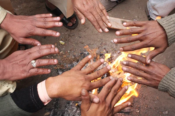 Men warm hands over the fire in India, Agra