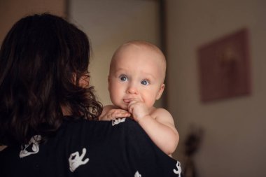 Sevgi dolu bir aile. Anne yatak odasında bebeğiyle oynuyor..