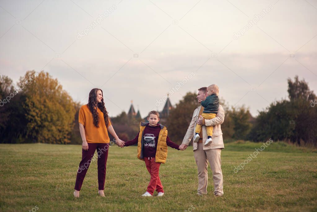 Happy family with two sons walking in the park. Funny family