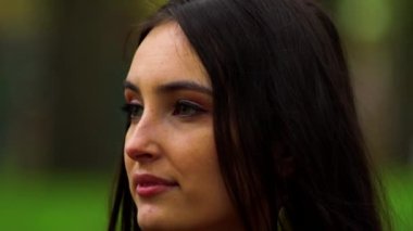 Genç güzel kız gülümser ve etrafına bakar.