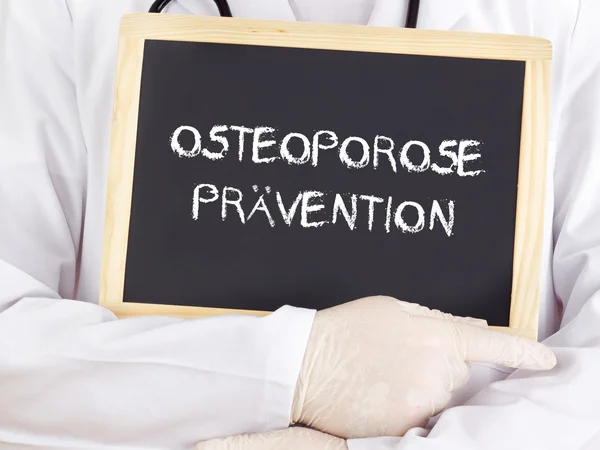 Doctor shows information: osteoporosis prevention in german — Stock Photo, Image