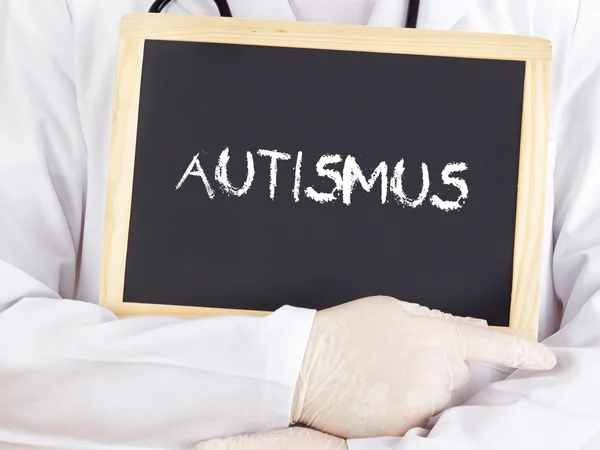 Doctor shows information on blackboard: autism in german — Stock Photo, Image