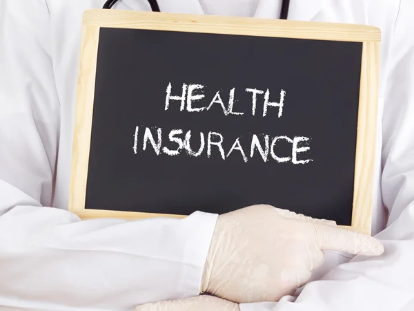 医師は、黒板の情報を表示: 健康保険 — ストック写真