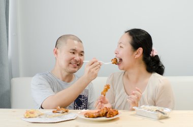 Mutlu sevgilisi kızarmış tavuk evde yemek.