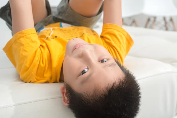 Asian boy resting comfortably on his bed — Stock Photo, Image