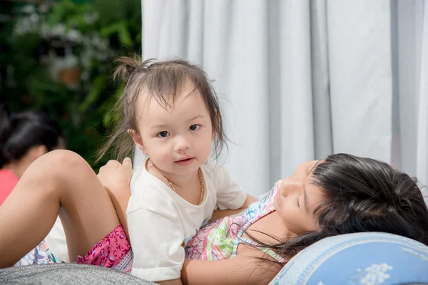 Söt asiatisk Tjej leker med hennes syster på säng hemma. — Stockfoto