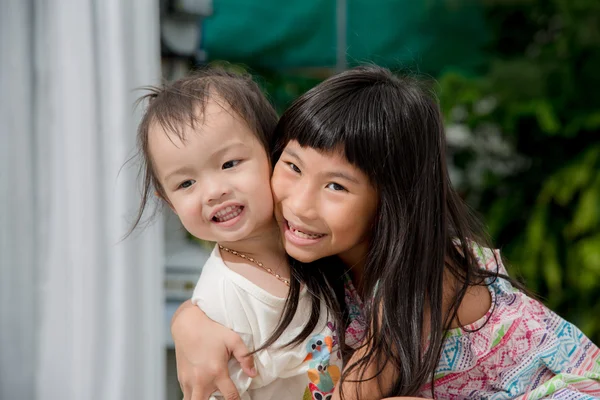 Cute Asian girl playing with her sister on bed at home. — Stock Photo, Image