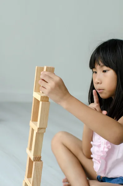 Asiatico bambini giocare legno blocchi a casa . — Foto Stock