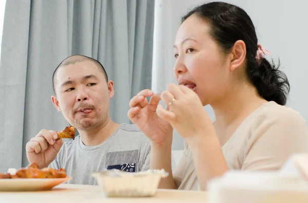 Feliz amante comiendo pollo frito en casa . — Foto de Stock