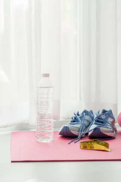 Chaussures de sport, tapis de yoga, bouteille d'eau et centimètre sur bois — Photo