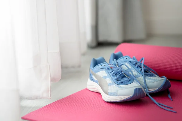 Zapatos deportivos azules en estera de yoga rosa con luz de la naturaleza en la morni —  Fotos de Stock