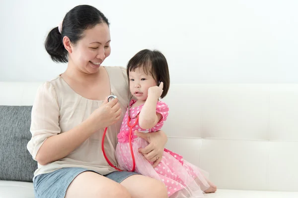 Das kleine Mädchen mit ihrer Mutter spielte in Ärzten — Stockfoto