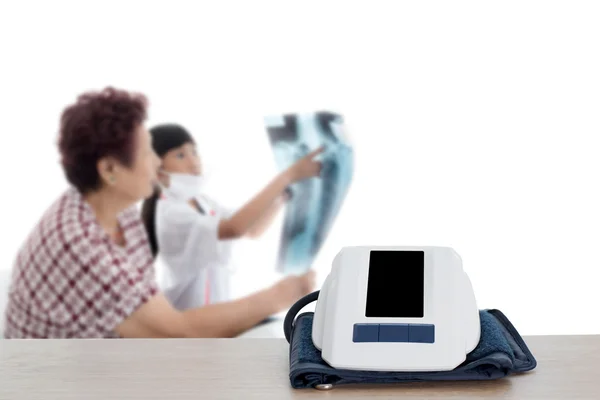 Blood measuring on table top with blurry senior with doctor, hea — Stock Photo, Image