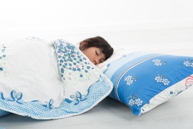 Asyalı kız yatakta uyuyan battaniye ile örtülü