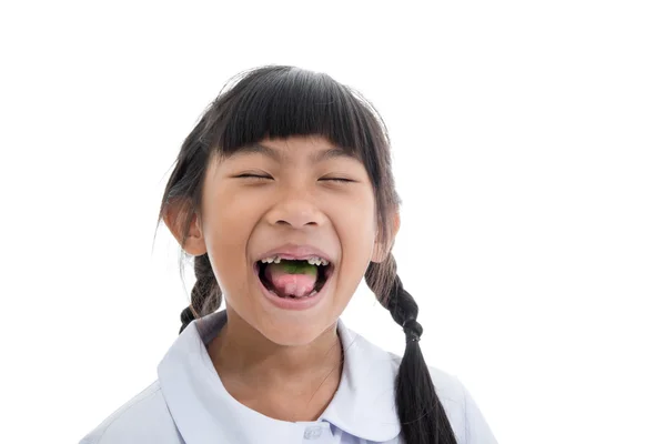Carino asiatico ragazza in uniforme mostrando il suo rotto denti su bianco bac — Foto Stock