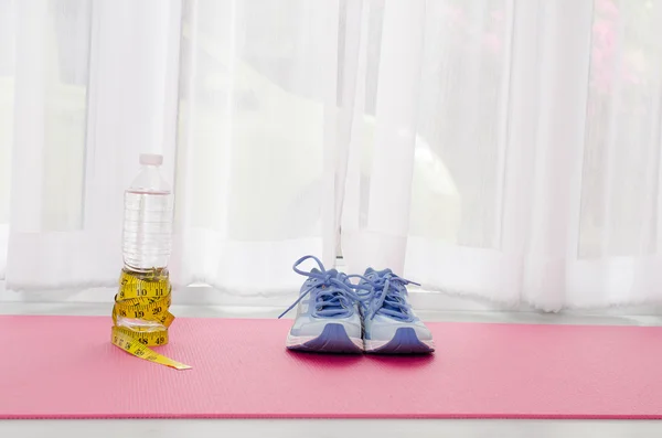 Sport shoes, yoga mat, bottle of water and centimeter on wooden — Stock Photo, Image