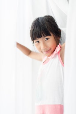 Beyaz perde evde kopya alanı ile tutarak mutlu Asyalı kız.